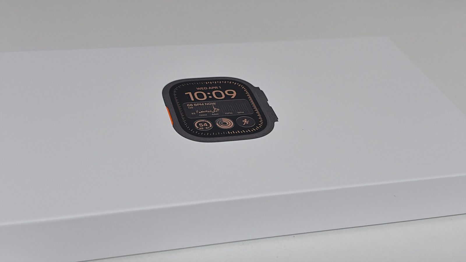 Apple Watch の白い箱。ふたに時計の画面の写真がある