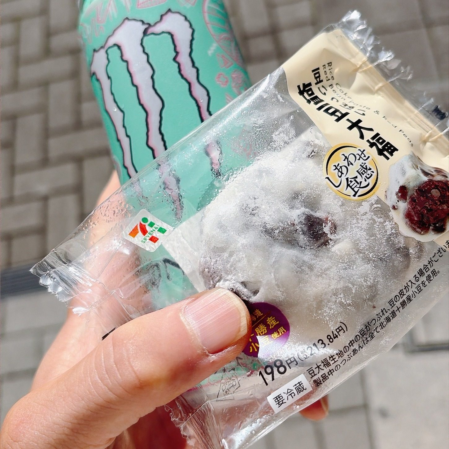 手に持った豆大福と、ミント色のモンスターの缶