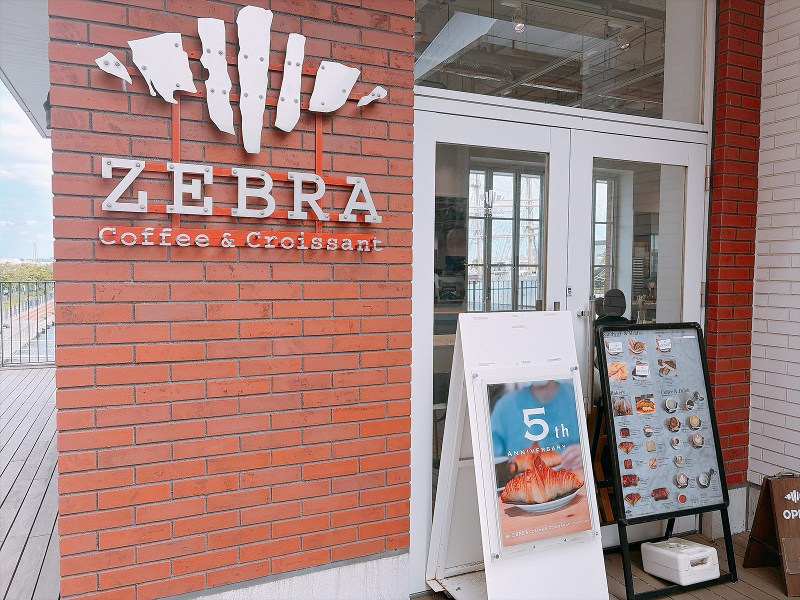 ZEBRA Coffee & Croissant の店の前。レンガの壁の看板