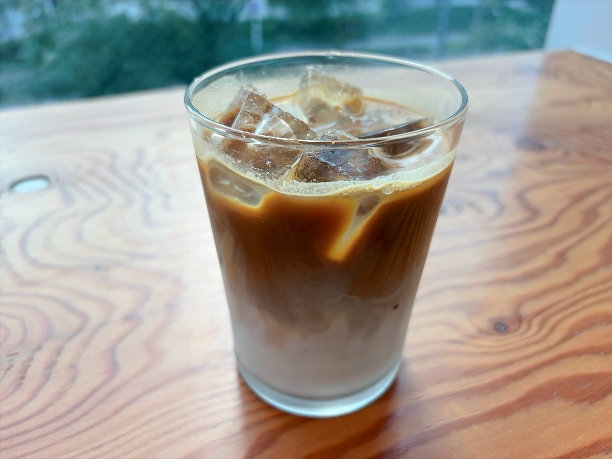 ZEBRA Coffee & Croissant のアイスラテ。木のテーブル